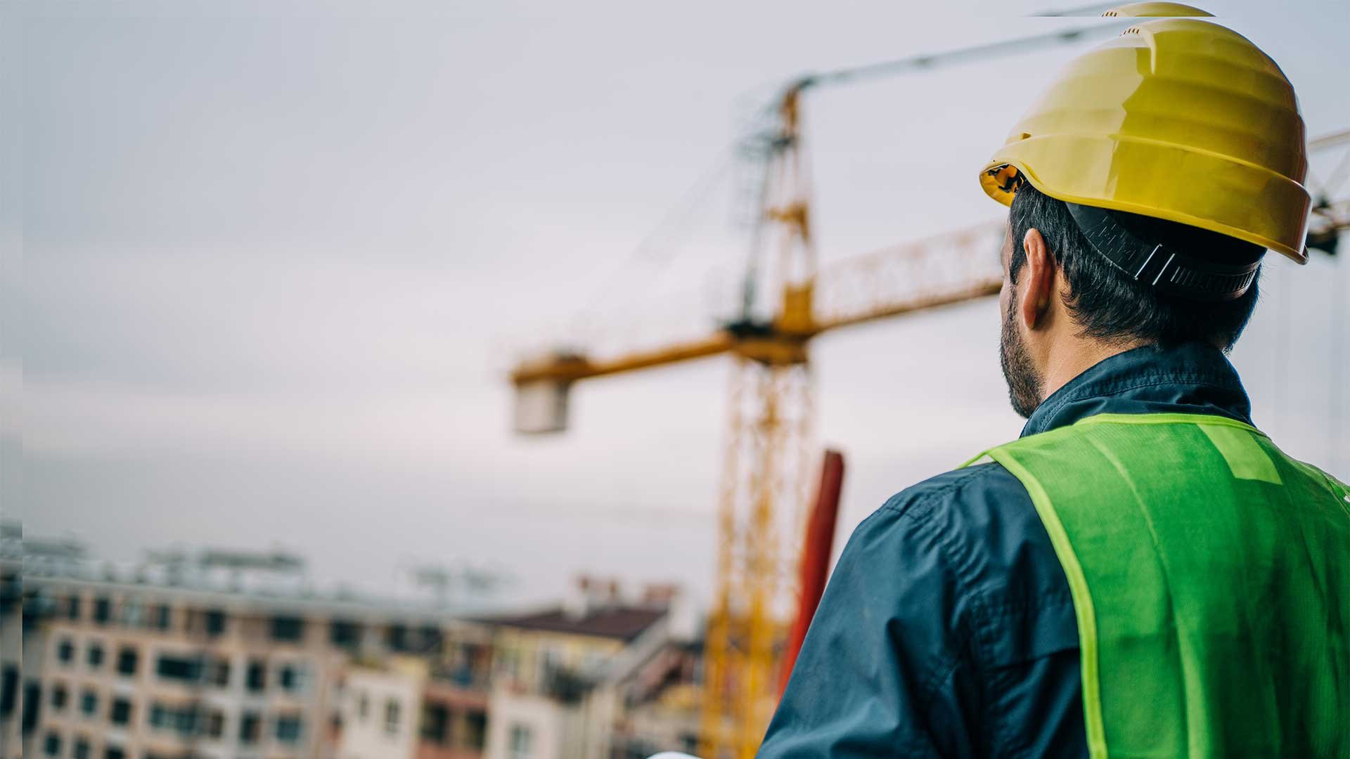 A construction worker looking out over a building site