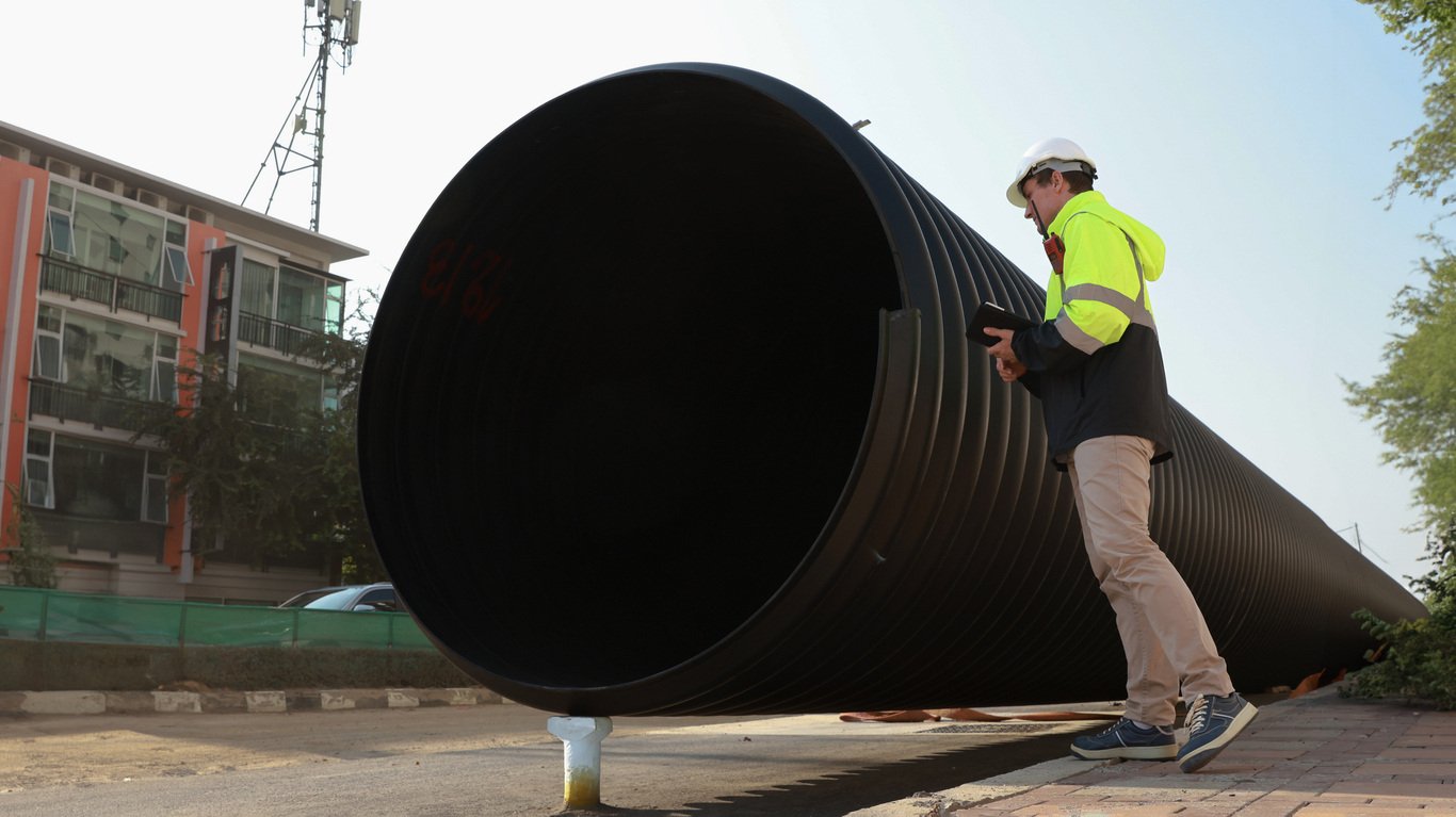 Engineer inspecting a large drainage pipe, utilizing Causeway Flow software for optimal hydraulic design