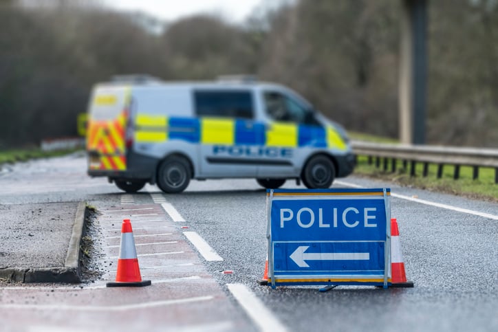 iStock-648761952 Police Sign on Road with Police Van stock photo